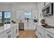 Beautiful kitchen has white cabinetry, stainless steel appliances, and granite countertop overlooking a water view at 3869 Shoreside Dr, Kissimmee, FL 34746