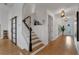 Bright foyer with a wood staircase, a black accent wall, and stylish decor at 3869 Shoreside Dr, Kissimmee, FL 34746