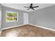 The gray bedroom is well-lit and has a ceiling fan and an exterior view at 5390 Botany Ct, Orlando, FL 32811