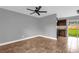 Spacious living area with tile floors, modern ceiling fan and adjacent kitchen at 5390 Botany Ct, Orlando, FL 32811