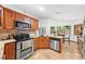 Well-lit kitchen with granite countertops, stainless steel appliances, and wooden cabinetry at 615 Maple Forest Dr, Orlando, FL 32825