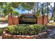 Entrance to the Sanctuary at Bay Hill community with lush landscaping and mature trees at 7863 Sugar Bend Dr # 7863, Orlando, FL 32819