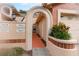 Inviting townhome entrance with an arched doorway, tidy landscaping, and visible unit numbers at 7863 Sugar Bend Dr # 7863, Orlando, FL 32819