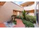Landscaped courtyard with tropical plants, a pathway, and neutral building tones at 7863 Sugar Bend Dr # 7863, Orlando, FL 32819