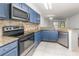 Bright kitchen with granite countertops, stainless steel appliances, and attractive blue cabinetry at 7863 Sugar Bend Dr # 7863, Orlando, FL 32819