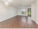 Spacious living area featuring wood floors, a modern chandelier, and a glass patio door at 7863 Sugar Bend Dr # 7863, Orlando, FL 32819