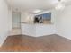 Open-concept living room with hardwood floors, white walls, and an adjacent kitchen area featuring blue cabinets at 7863 Sugar Bend Dr # 7863, Orlando, FL 32819