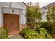 Inviting covered front entryway featuring double doors, brick accents, and lush landscaping at 8044 Rural Retreat Ct, Orlando, FL 32819