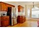 Bright kitchen with stainless steel refrigerator, wood cabinets, stone countertops, and hardwood floors at 8044 Rural Retreat Ct, Orlando, FL 32819