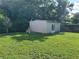 Backyard with lush green grass and a modern shed with French doors at 907 N Hyer Ave, Orlando, FL 32803