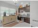 Coffee bar, mini fridge, and storage cabinets within the home featuring tile flooring, lots of light, and decorations at 924 Figwood Loop, The Villages, FL 32163