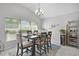 Dining room features a sleek modern table set for a meal with stylish decor and a large window providing natural light at 924 Figwood Loop, The Villages, FL 32163