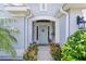 Charming home featuring a light blue front door adorned with a wreath, surrounded by lush landscaping at 924 Figwood Loop, The Villages, FL 32163