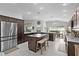 Inviting kitchen showcasing dark wood cabinets, stainless appliances, a center island with breakfast bar and seating at 924 Figwood Loop, The Villages, FL 32163