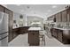 Spacious kitchen featuring rich wood cabinetry, stainless appliances, center island, and tile flooring throughout at 924 Figwood Loop, The Villages, FL 32163