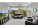 Bright living room with large windows offering a view of the lush landscaping and comfortable seating at 924 Figwood Loop, The Villages, FL 32163