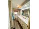 A full shot of the bathroom shows the single sink, vanity, commode and shower at 103 Poinsettia Cv, Leesburg, FL 34748