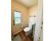 Cozy bathroom featuring wood-look vinyl flooring, a window, and neutral decor at 103 Poinsettia Cv, Leesburg, FL 34748