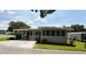 Charming single-story home with a carport and manicured lawn under a sunny sky at 103 Poinsettia Cv, Leesburg, FL 34748
