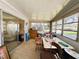 Enclosed sunroom with sliding glass door access, windows, and ample seating space at 103 Poinsettia Cv, Leesburg, FL 34748