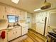 Functional kitchen with wood-look floors, white cabinets, and ample storage at 103 Poinsettia Cv, Leesburg, FL 34748