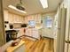 Functional kitchen with wood-look floors, white cabinets, and side door at 103 Poinsettia Cv, Leesburg, FL 34748