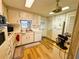 Functional kitchen with wood-look floors, white cabinets, and good natural light at 103 Poinsettia Cv, Leesburg, FL 34748