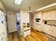 Functional kitchen with wood-look floors and white cabinets that connects to the dining area at 103 Poinsettia Cv, Leesburg, FL 34748
