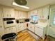 Functional kitchen with wood-look floors and white cabinets at 103 Poinsettia Cv, Leesburg, FL 34748