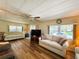 Spacious living room with ample natural light, wood floors, and comfortable couches at 103 Poinsettia Cv, Leesburg, FL 34748