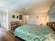 The main bedroom is shown with a ceiling fan, hard floors and wood furniture at 103 Poinsettia Cv, Leesburg, FL 34748