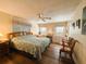 A view of the main bedroom showcases a wooden headboard, ceiling fan and hard floors at 103 Poinsettia Cv, Leesburg, FL 34748