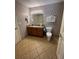 Well-maintained bathroom with patterned wallpaper, a granite vanity, and tiled floors at 1310 Seven Eagles Ct # 102, Reunion, FL 34747