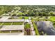 Expansive aerial view of the community featuring lush greenery, streets, a pond, and low buildings at 1330 Englewood Dr, St Cloud, FL 34772