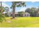Single-story home with brick facade, dark shutters, mature tree, and lush green lawn at 1330 Englewood Dr, St Cloud, FL 34772