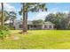 Well-maintained single-story home with a brick facade, dark shutters, mature tree, and lush green lawn at 1330 Englewood Dr, St Cloud, FL 34772