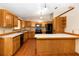 Open kitchen with wood cabinetry, tile countertops, and an island at 1330 Englewood Dr, St Cloud, FL 34772