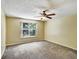 Bedroom with neutral walls, carpeting, ceiling fan and a window allowing for natural light at 310 Dagama Ct, Kissimmee, FL 34758