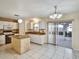 Well-lit kitchen featuring an island, white cabinets and sliding glass doors to lanai at 310 Dagama Ct, Kissimmee, FL 34758