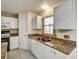 Galley kitchen with white cabinetry, granite counters, and stainless steel appliances at 310 Dagama Ct, Kissimmee, FL 34758