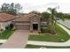 Beautiful single-story home features a brick paver driveway and manicured lawn with a palm tree at 4004 Prima Lago Cir, Lakeland, FL 33810