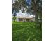Serene backyard view with lush green lawn and mature tree providing ample shade at 527 San Pedro Dr, The Villages, FL 32159