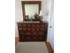 Bedroom featuring a large wood dresser, mirror, neutral walls, and hardwood floors at 527 San Pedro Dr, The Villages, FL 32159