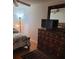 Well-lit bedroom featuring a wooden dresser with a mounted television at 527 San Pedro Dr, The Villages, FL 32159