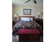 Cozy bedroom featuring a decorative black bedspread and a cherry colored storage bench at 527 San Pedro Dr, The Villages, FL 32159