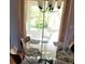 Dining area with a modern glass-top table, stylish chairs, and natural light from a large window at 527 San Pedro Dr, The Villages, FL 32159
