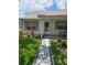 Charming home entrance with a walkway, manicured lawn, and colorful garden at 527 San Pedro Dr, The Villages, FL 32159