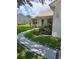 Attractive home with a curved walkway leading to the entrance, framed by lush landscaping at 527 San Pedro Dr, The Villages, FL 32159