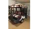 Indoor view of a white golf cart with striped canopy and seats parked in the garage at 527 San Pedro Dr, The Villages, FL 32159