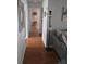 Hallway with hardwood floors leading to a neutrally painted room with flat screen television at 527 San Pedro Dr, The Villages, FL 32159